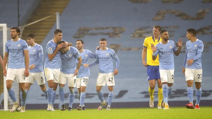 Manchester City players celebrate after Manchester Citys Phil Foden, centre, scored his sides opening goal during the English Premier League soccer match between Manchester City and Brighton and Hove Albion at the Etihad Stadium in Manchester, England, Wednesday, Jan. 13, 2021. (Martin Rickett /Pool via AP)