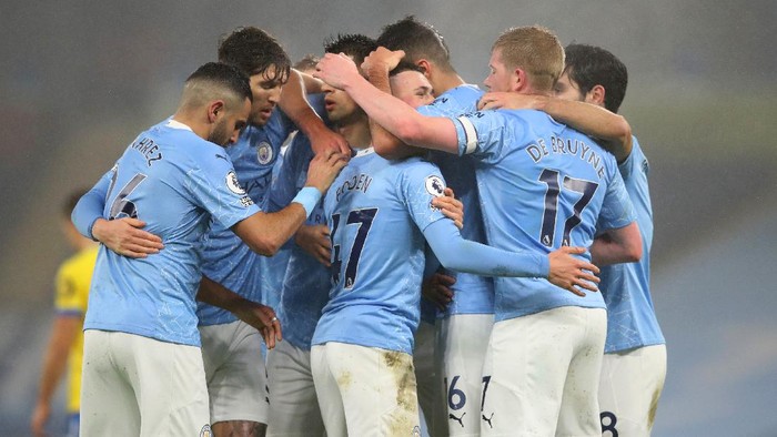 MANCHESTER, ENGLAND - JANUARY 13: Phil Foden of Manchester City celebrates with teammates Rodrigo, Kevin De Bruyne and Ilkay Guendogan after scoring their teams first goal during the Premier League match between Manchester City and Brighton & Hove Albion at Etihad Stadium on January 13, 2021 in Manchester, England. Sporting stadiums around England remain under strict restrictions due to the Coronavirus Pandemic as Government social distancing laws prohibit fans inside venues resulting in games being played behind closed doors. (Photo by Clive Brunskill/Getty Images)