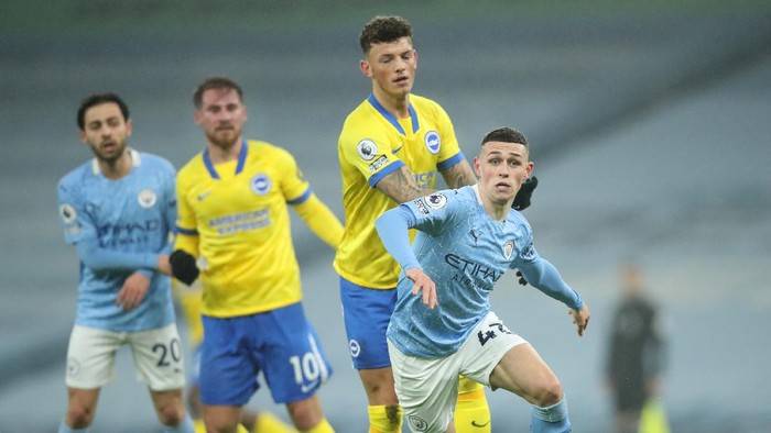 MANCHESTER, ENGLAND - JANUARY 13: Phil Foden of Manchester City makes a break during the Premier League match between Manchester City and Brighton & Hove Albion at Etihad Stadium on January 13, 2021 in Manchester, England. Sporting stadiums around England remain under strict restrictions due to the Coronavirus Pandemic as Government social distancing laws prohibit fans inside venues resulting in games being played behind closed doors. (Photo by Clive Brunskill/Getty Images)