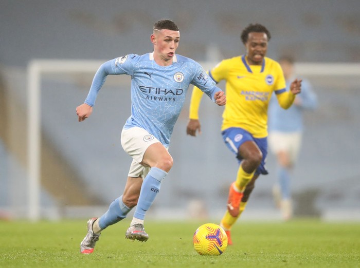 MANCHESTER, ENGLAND - JANUARY 13: Phil Foden of Manchester City makes a break during the Premier League match between Manchester City and Brighton & Hove Albion at Etihad Stadium on January 13, 2021 in Manchester, England. Sporting stadiums around England remain under strict restrictions due to the Coronavirus Pandemic as Government social distancing laws prohibit fans inside venues resulting in games being played behind closed doors. (Photo by Clive Brunskill/Getty Images)