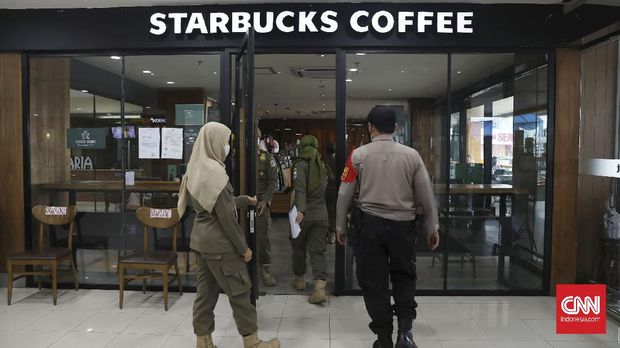 Sejumlah petugas Satpol PP Kecamatan Cilandak melakukan inspeksi protkes PPKM di sejumlah tempat makan di kawasan Fatmawati, Jaksel, Kamis, 14 Januari 2020. Bagi tempat makan yang melanggar protkes PPKM petugas memberikan teguran tertulis yang ditempelkan di depan toko/tempat makan pemilik. CNNIndonesia/Safir Makki