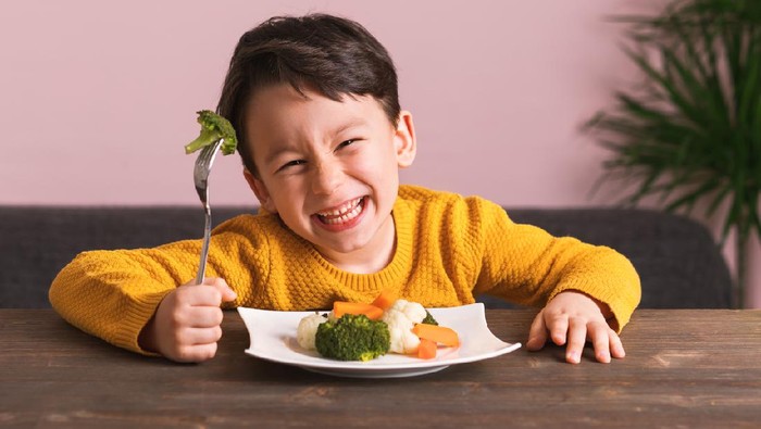 904661696 Child is eating vegetables. He is very happy.