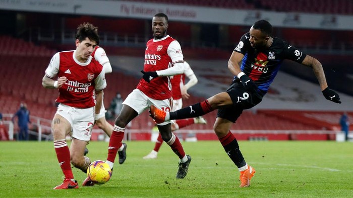 LONDON, ENGLAND - JANUARY 14: Jordan Ayew of Crystal Palace shoots as Hactor Bellerin of Arsenal blocks during the Premier League match between Arsenal and Crystal Palace at Emirates Stadium on January 14, 2021 in London, England. Sporting stadiums around England remain under strict restrictions due to the Coronavirus Pandemic as Government social distancing laws prohibit fans inside venues resulting in games being played behind closed doors. (Photo by Alastair Grant - Pool/Getty Images)