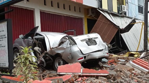 Sebuah mobil dan bangunan rusak akibat gempa bumi, di Mamuju, Sulawesi Barat, Jumat (15/1/2021). Petugas BPBD Sulawesi Barat masih mendata jumlah kerusakan dan korban akibat gempa bumi berkekuatan magnitudo 6,2 tersebut. ANTARA FOTO/Akbar Tado/wpa/hp.