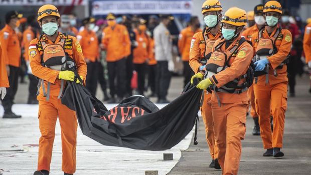 Personel Basarnas mengangkat kantong jenazah berisi objek temuan dari lokasi jatuhnya pesawat Sriwijaya Air PK-CLC nomor penerbangan SJ 182 rute Jakarta-Pontianak pada hari keenam Operasi SAR pesawat tersebut di Dermaga JICT, Tanjung Priok, Jakarta Utara, Kamis (14/1/2021). ANTARA FOTO/Aprillio Akbar/wsj.