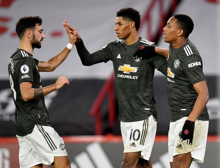 Marcus Rashford SHEFFIELD, ENGLAND - DECEMBER 17: Marcus Rashford of Manchester United celebrates with team mates (l - r) Bruno Fernandes and Anthony Martial after scoring their sides third goal during the Premier League match between Sheffield United and Manchester United at Bramall Lane on December 17, 2020 in Sheffield, England. The match will be played without fans, behind closed doors as a Covid-19 precaution. (Photo by Peter Powell - Pool/Getty Images)