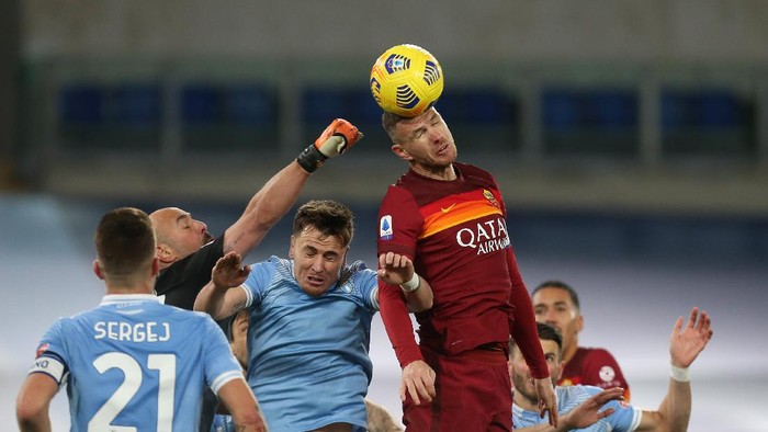 ROME, ITALY - JANUARY 15: Edin Dzeko of Roma gets above Patric (centre) and goalkeeper Pepe Reina of Lazio during the Serie A match between SS Lazio and AS Roma at Stadio Olimpico on January 15, 2021 in Rome, Italy.  (Photo by Paolo Bruno/Getty Images)
