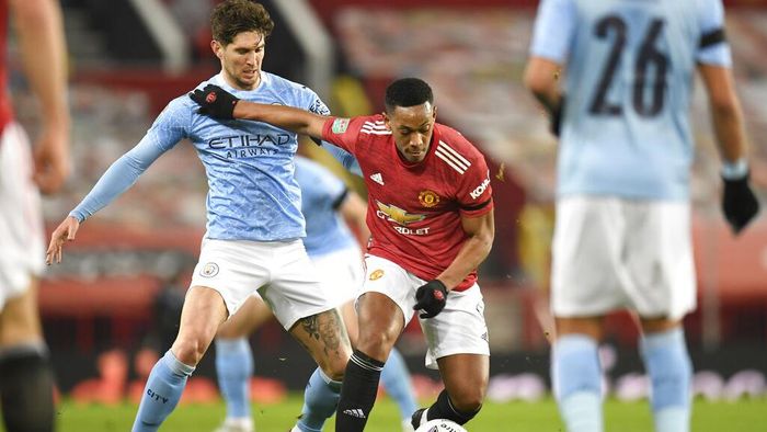Manchester United vs Manchester City Manchester Citys John Stones, left, and Manchester Uniteds Anthony Martial fight for the ball during the English League Cup semifinal soccer match between Manchester United and Manchester City at Old Trafford in Manchester, England, Wednesday, Jan. 6, 2021. (Peter Powell/Pool via AP)