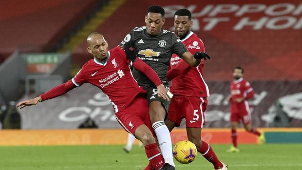 Manchester United's Anthony Martial fights for the ball with Liverpool's Fabinho, left, during the English Premier League soccer match between Liverpool and Manchester United at Anfield Stadium, Liverpool, England, Sunday, Jan. 17, 2021. (Paul Ellis/Pool via AP)