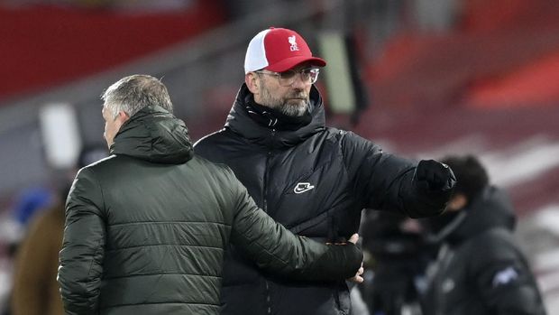 Liverpool's manager Jurgen Klopp, right, and Manchester United's manager Ole Gunnar Solskjaer greet each other at the end of the English Premier League soccer match between Liverpool and Manchester United at Anfield Stadium, Liverpool, England, Sunday, Jan. 17, 2021.(Michael Regan/Pool via AP)