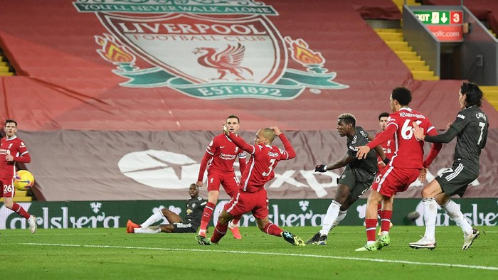 LIVERPOOL, ENGLAND - JANUARY 17: Paul Pogba of Manchester United has a shot saved whilst under pressure from Fabinho of Liverpool during the Premier League match between Liverpool and Manchester United at Anfield on January 17, 2021 in Liverpool, England. Sporting stadiums around England remain under strict restrictions due to the Coronavirus Pandemic as Government social distancing laws prohibit fans inside venues resulting in games being played behind closed doors. (Photo by Michael Regan/Getty Images)