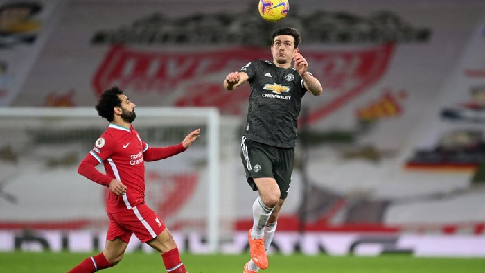 LIVERPOOL, ENGLAND - JANUARY 17: Harry Maguire of Manchester United heads the ball whilst under pressure from Mohamed Salah of Liverpool during the Premier League match between Liverpool and Manchester United at Anfield on January 17, 2021 in Liverpool, England. Sporting stadiums around England remain under strict restrictions due to the Coronavirus Pandemic as Government social distancing laws prohibit fans inside venues resulting in games being played behind closed doors. (Photo by Michael Regan/Getty Images)
