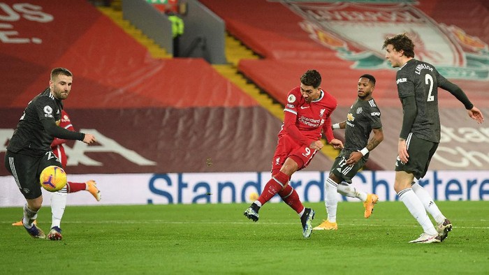 LIVERPOOL, ENGLAND - JANUARY 17: Roberto Firminho of Liverpool shoots whilst under pressure from (L - R) Luke Shaw, Fred and Victor Lindelof of Manchester United during the Premier League match between Liverpool and Manchester United at Anfield on January 17, 2021 in Liverpool, England. Sporting stadiums around England remain under strict restrictions due to the Coronavirus Pandemic as Government social distancing laws prohibit fans inside venues resulting in games being played behind closed doors. (Photo by Michael Regan/Getty Images)