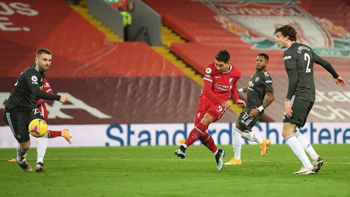 Liverpool vs Manchester United LIVERPOOL, ENGLAND - JANUARY 17: Roberto Firminho of Liverpool shoots whilst under pressure from (L - R) Luke Shaw, Fred and Victor Lindelof of Manchester United during the Premier League match between Liverpool and Manchester United at Anfield on January 17, 2021 in Liverpool, England. Sporting stadiums around England remain under strict restrictions due to the Coronavirus Pandemic as Government social distancing laws prohibit fans inside venues resulting in games being played behind closed doors. (Photo by Michael Regan/Getty Images)
