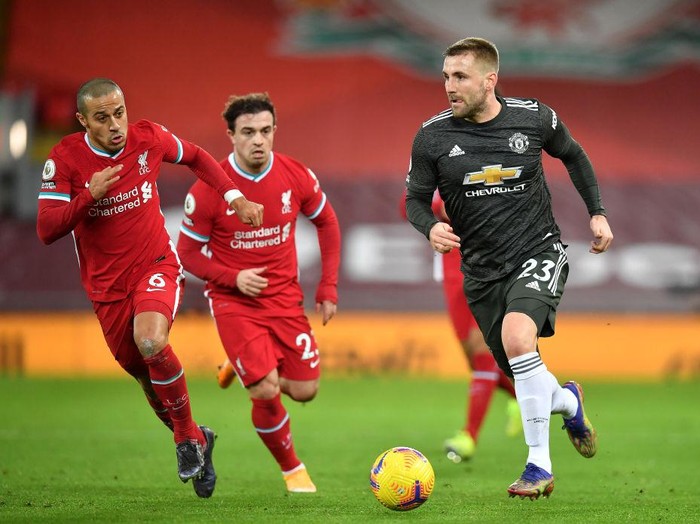 LIVERPOOL, ENGLAND - JANUARY 17: Luke Shaw of Manchester United runs with the ball whilst being closed down by Thiago Alcantara of Liverpool during the Premier League match between Liverpool and Manchester United at Anfield on January 17, 2021 in Liverpool, England. Sporting stadiums around England remain under strict restrictions due to the Coronavirus Pandemic as Government social distancing laws prohibit fans inside venues resulting in games being played behind closed doors. (Photo by Paul Ellis - Pool/Getty Images)