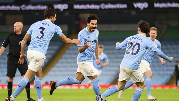 MANCHESTER, ENGLAND - JANUARY 17: Ilkay Gundogan of Manchester City celebrates with team mates (L - R) Ruben Dias and Bernardo Silva after scoring their sides second goal during the Premier League match between Manchester City and Crystal Palace at Etihad Stadium on January 17, 2021 in Manchester, England. Sporting stadiums around England remain under strict restrictions due to the Coronavirus Pandemic as Government social distancing laws prohibit fans inside venues resulting in games being played behind closed doors.  (Photo by Clive Brunskill/Getty Images)