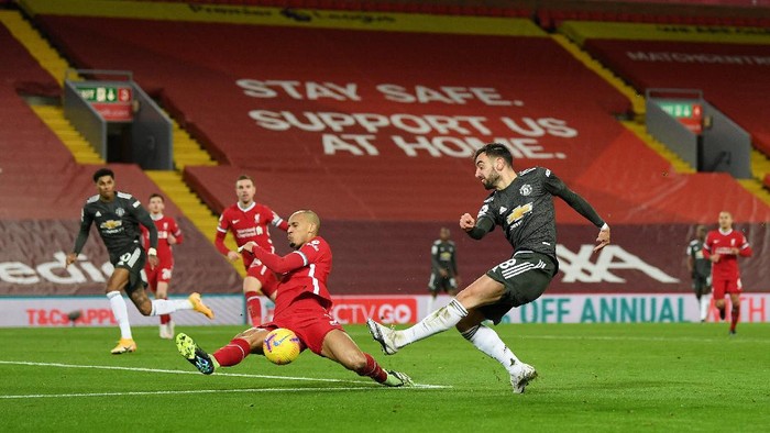 LIVERPOOL, ENGLAND - JANUARY 17: Bruno Fernandes of Manchester United has a shot blocked by Fabinho of Liverpool during the Premier League match between Liverpool and Manchester United at Anfield on January 17, 2021 in Liverpool, England. Sporting stadiums around England remain under strict restrictions due to the Coronavirus Pandemic as Government social distancing laws prohibit fans inside venues resulting in games being played behind closed doors. (Photo by Michael Regan/Getty Images)