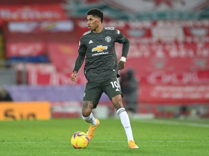 LIVERPOOL, ENGLAND - JANUARY 17: Marcus Rashford of Manchester United runs with the ball during the Premier League match between Liverpool and Manchester United at Anfield on January 17, 2021 in Liverpool, England. Sporting stadiums around England remain under strict restrictions due to the Coronavirus Pandemic as Government social distancing laws prohibit fans inside venues resulting in games being played behind closed doors. (Photo by Michael Regan/Getty Images)