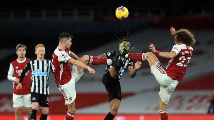 LONDON, ENGLAND - JANUARY 18: Callum Wilson of Newcastle United is challenged by Granit Xhaka of Arsenal (L) and David Luiz of Arsenal (R) during the Premier League match between Arsenal and Newcastle United at Emirates Stadium on January 18, 2021 in London, England. Sporting stadiums around England remain under strict restrictions due to the Coronavirus Pandemic as Government social distancing laws prohibit fans inside venues resulting in games being played behind closed doors. (Photo by Adam Davy -