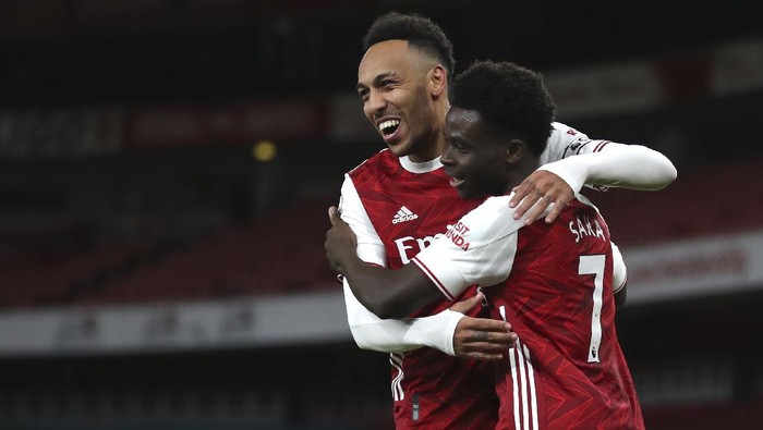 Arsenals Bukayo Saka, right, celebrates with Pierre-Emerick Aubameyang after scoring his sides second goal during the English Premier League soccer match between Arsenal and Newcastle United at Emirates Stadium in London, England, Monday, Jan.18, 2021. (Catherine Ivill/Pool via AP)