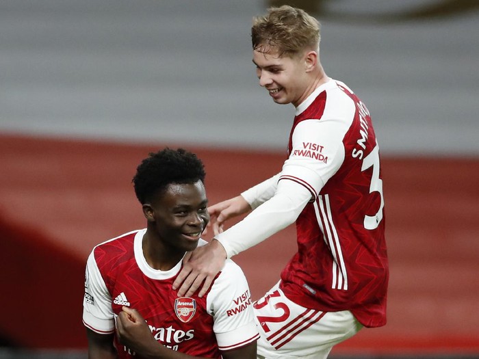 LONDON, ENGLAND - DECEMBER 26: Bukayo Saka of Arsenal celebrates with teammates Emile Smith Rowe after scoring his teams third goal  during the Premier League match between Arsenal and Chelsea at Emirates Stadium on December 26, 2020 in London, England. The match will be played without fans, behind closed doors as a Covid-19 precaution. (Photo by Andrew Boyers - Pool/Getty Images)
