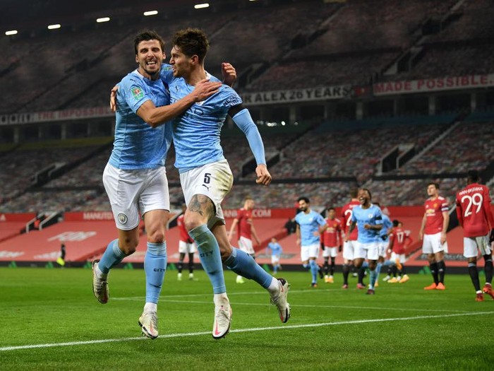 MANCHESTER, ENGLAND - JANUARY 06: John Stones of Manchester City celebrates at the final whistle with Ruben Dias of Manchester City during the Carabao Cup Semi Final match between Manchester United and Manchester City at Old Trafford on January 06, 2021 in Manchester, England. The match will be played without fans, behind closed doors as a Covid-19 precaution. (Photo by Peter Powell - Pool/Getty Images)