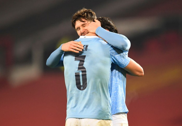 MANCHESTER, ENGLAND - JANUARY 06: John Stones of Manchester City celebrates at the final whistle with Ruben Dias of Manchester City during the Carabao Cup Semi Final match between Manchester United and Manchester City at Old Trafford on January 06, 2021 in Manchester, England. The match will be played without fans, behind closed doors as a Covid-19 precaution. (Photo by Peter Powell - Pool/Getty Images)