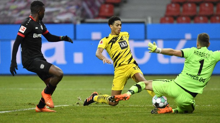 jude bellingham bayer leverkusen borussia dortmund lukas hradecky liga jerman bundesliga Dortmunds Jude Bellingham takes a shot at goal next to Leverkusens goalkeeper Lukas Hradecky during the German Bundesliga soccer match between Bayer Leverkusen and Borussia Dortmund in Leverkusen, Germany, Tuesday, Jan. 19, 2021. (AP Photo/Martin Meissner, Pool)