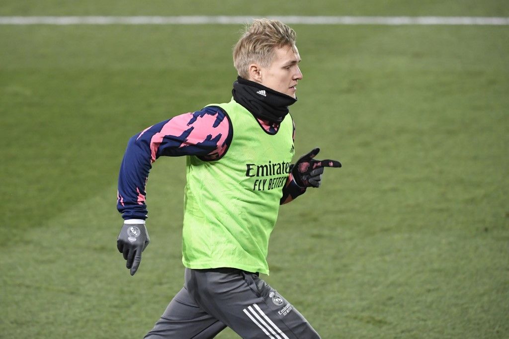 Real Madrid's Norwegian midfielder Martin Odegaard warms up on the sidelines during the Spanish League football match between Real Madrid and Celta Vigo at the Alfredo Di Stefano stadium in Valdebebas, northeast of Madrid, on January 2, 2021. (Photo by OSCAR DEL POZO / AFP)
