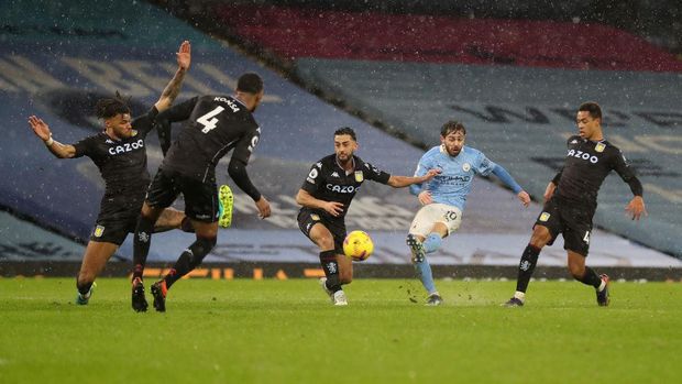 MANCHESTER, ENGLAND - JANUARY 20: Bernardo Silva of Manchester City scores their side's first goal during the Premier League match between Manchester City and Aston Villa at Etihad Stadium on January 20, 2021 in Manchester, England. Sporting stadiums around the UK remain under strict restrictions due to the Coronavirus Pandemic as Government social distancing laws prohibit fans inside venues resulting in games being played behind closed doors. (Photo by Martin Rickett - Pool/Getty Images)