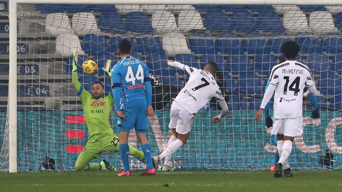 REGGIO NELLEMILIA, ITALY - JANUARY 20: Cristiano Ronaldo of Juventus scores their sides first goal during the Italian PS5 Supercup match between Juventus and SSC Napoli at Mapei Stadium - Citta del Tricolore on January 20, 2021 in Reggio nellEmilia, Italy. Sporting stadiums around Italy remain under strict restrictions due to the Coronavirus Pandemic as Government social distancing laws prohibit fans inside venues resulting in games being played behind closed doors. (Photo by Marco Luzzani/Getty Images)