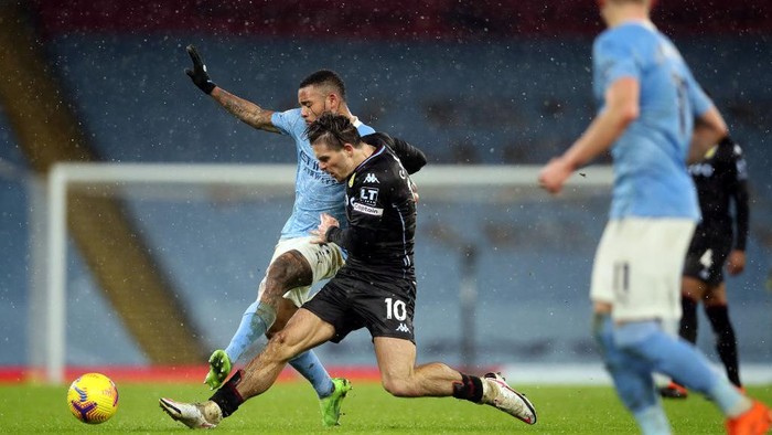 MANCHESTER, ENGLAND - JANUARY 20: Jack Grealish of Aston Villa and Gabriel Jesus of Manchester City battle for the ball  during the Premier League match between Manchester City and Aston Villa at Etihad Stadium on January 20, 2021 in Manchester, England. Sporting stadiums around the UK remain under strict restrictions due to the Coronavirus Pandemic as Government social distancing laws prohibit fans inside venues resulting in games being played behind closed doors. (Photo by Clive Brunskill/Getty Images)