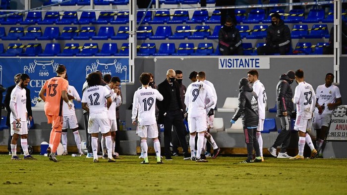 Real Madrids head coach Zinedine Zidane, centre speaks with his players as the Spanish Copa del Rey round of 32 soccer match between Alcoyano and Real Madrid goes into extra time at the El Collao stadium in Alcoy, Spain, Wednesday Jan. 20, 2021. (AP Photo/Jose Breton)