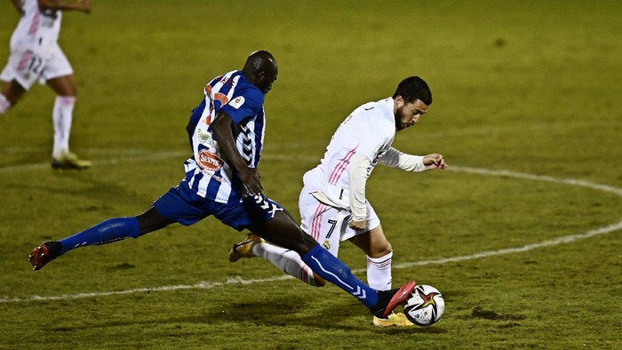 Alcoyanos Ali Diakite, left, challenges for the ball with Real Madrids Eden Hazard during a Spanish Copa del Rey round of 32 soccer match between Alcoyano and Real Madrid at the El Collao stadium in Alcoy, Spain, Wednesday Jan. 20, 2021. (AP Photo/Jose Breton)