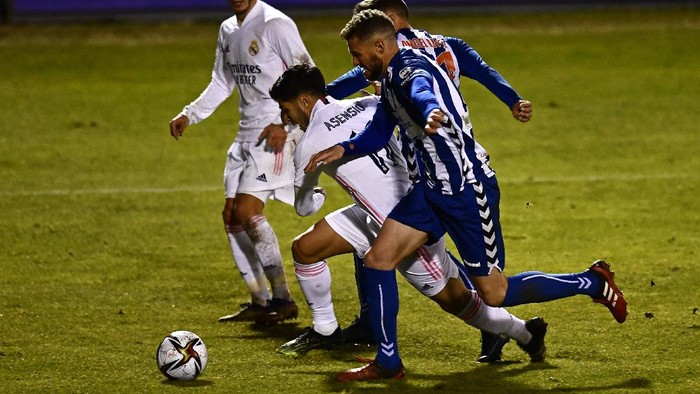 Real Madrids Marco Asensio, centre charges through the Alcoyano defence during a Spanish Copa del Rey round of 32 soccer match between Alcoyano and Real Madrid at the El Collao stadium in Alcoy, Spain, Wednesday Jan. 20, 2021. (AP Photo/Jose Breton)
