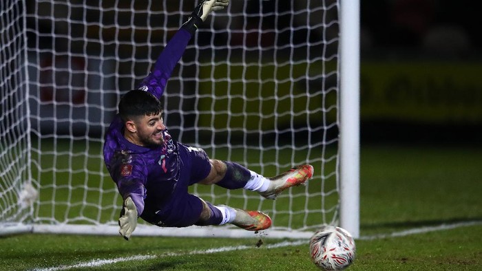 NEWPORT, WALES - JANUARY 10: Tom King of Newport County saves a penalty from Neal Maupay of Brighton and Hove Albion (not pictured) in the shootout during the FA Cup Third Round match between Newport County and Brighton And Hove Albion at Rodney Parade on January 10, 2021 in Newport, Wales. Sporting stadiums around Wales remain under strict restrictions due to the Coronavirus Pandemic as Government social distancing laws prohibit fans inside venues resulting in games being played behind closed doors. (Photo by Michael Steele/Getty Images)