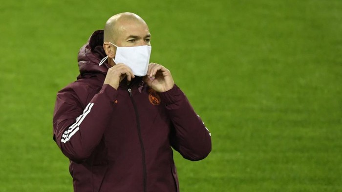 (FILES) In this file photo taken on October 26, 2020 Real Madrids French coach Zinedine Zidane ears a face mask during the training session on the eve of the UEFA Champions League group B football match  Borussia Moenchengladbach v Real Madrid in Moenchengladbach, western Germany. - Zinedine Zidane has tested positive for Covid-19, the club announced on January 22, 2021. (Photo by Ina FASSBENDER / AFP)