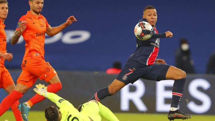 PSGs Kylian Mbappe, right, scores his sides opening goal during the French League One soccer match between Paris Saint-Germain and Montpellier at the Parc des Princes stadium in Paris, France, Friday, Jan.22, 2021. (AP Photo/Thibault Camus)
