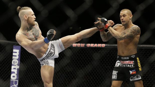 FILE - In this Sept. 27, 2014, file photo, Conor McGregor, left, kicks Dustin Poirier during their mixed martial arts bout in Las Vegas. McGregor returns from a year-long layoff for a rematch against Poirier in the promotions's first pay-per-view of the year, at UFC 257 on Jan. 24 at Abu Dhabi. (AP Photo/John Locher, File)