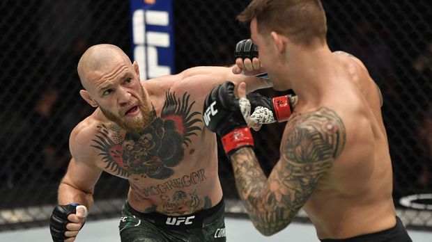 Jan 23, 2021; Abu Dhabi, United Arab Emirates; Conor McGregor of Ireland punches Dustin Poirier in a lightweight fight during the UFC 257 event inside Etihad Arena on UFC Fight Island. Mandatory Credit: Jeff Bottari/Handout Photo via USA TODAY Sports