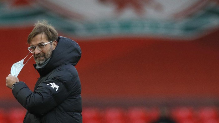 LIVERPOOL, ENGLAND - JANUARY 17: Jurgen Klopp, Manager of Liverpool removes his face mask ahead of being interviewed prior to kick off during the Premier League match between Liverpool and Manchester United at Anfield on January 17, 2021 in Liverpool, England. Sporting stadiums around England remain under strict restrictions due to the Coronavirus Pandemic as Government social distancing laws prohibit fans inside venues resulting in games being played behind closed doors. (Photo by Phil Noble - Pool/Getty Images)