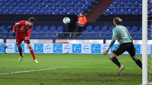 GELSENKIRCHEN, GERMANY - JANUARY 24: Thomas Muller of FC Bayern Muenchen scores their side's first goal past Ralf Fahrmann of FC Schalke 04 during the Bundesliga match between FC Schalke 04 and FC Bayern Muenchen at Veltins-Arena on January 24, 2021 in Gelsenkirchen, Germany. Sporting stadiums around Germany remain under strict restrictions due to the Coronavirus Pandemic as Government social distancing laws prohibit fans inside venues resulting in games being played behind closed doors. (Photo by Lars Baron/Getty Images)
