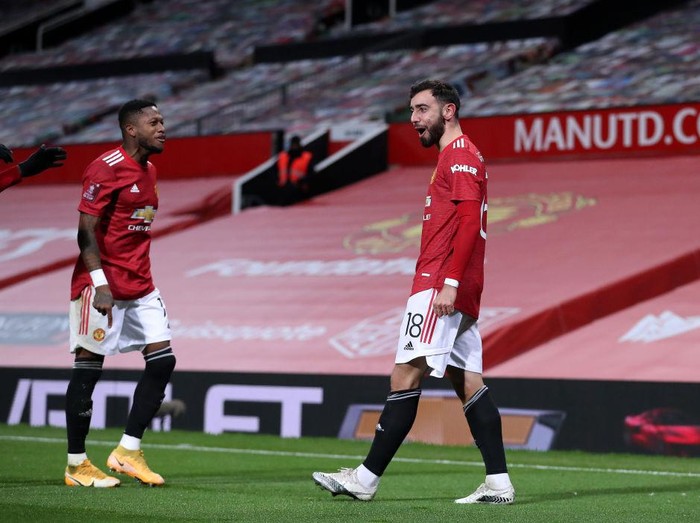 MANCHESTER, ENGLAND - JANUARY 24: Bruno Fernandes of Manchester United celebrates with team mate Fred (L) after scoring their sides third goal from a free kick during The Emirates FA Cup Fourth Round match between Manchester United and Liverpool at Old Trafford on January 24, 2021 in Manchester, England. Sporting stadiums around the UK remain under strict restrictions due to the Coronavirus Pandemic as Government social distancing laws prohibit fans inside venues resulting in games being played behind closed doors. (Photo by Martin Rickett - Pool/Getty Images)
