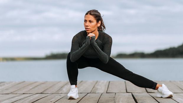 lustrasi Olahraga Side Lunge Part of young man in sportswear doing squat at gym