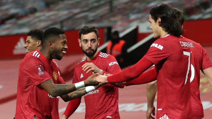 Manchester United MANCHESTER, ENGLAND - JANUARY 24: Bruno Fernandes of Manchester United celebrates with team mates (L - R) Fred and Edinson Cavani after scoring their sides third goal from a free kick during The Emirates FA Cup Fourth Round match between Manchester United and Liverpool at Old Trafford on January 24, 2021 in Manchester, England. Sporting stadiums around the UK remain under strict restrictions due to the Coronavirus Pandemic as Government social distancing laws prohibit fans inside venues resulting in games being played behind closed doors. (Photo by Martin Rickett - Pool/Getty Images)