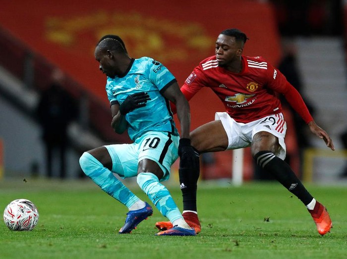 MANCHESTER, ENGLAND - JANUARY 24: Aaron Wan-Bissaka of Manchester United battles for possession with Sadio Mane of Liverpool during The Emirates FA Cup Fourth Round match between Manchester United and Liverpool at Old Trafford on January 24, 2021 in Manchester, England. Sporting stadiums around the UK remain under strict restrictions due to the Coronavirus Pandemic as Government social distancing laws prohibit fans inside venues resulting in games being played behind closed doors. (Photo by Phil Noble - Pool/Getty Images)