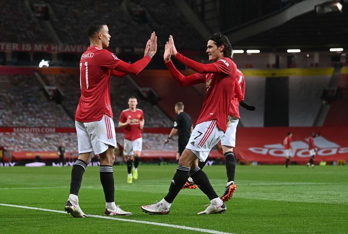 MANCHESTER, ENGLAND - JANUARY 24: Mason Greenwood of Manchester United celebrates after scoring their sides first goal  with team mate Edinson Cavani during The Emirates FA Cup Fourth Round match between Manchester United and Liverpool at Old Trafford on January 24, 2021 in Manchester, England. Sporting stadiums around the UK remain under strict restrictions due to the Coronavirus Pandemic as Government social distancing laws prohibit fans inside venues resulting in games being played behind closed doors. (Photo by Laurence Griffiths/Getty Images)