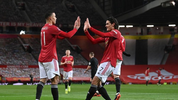 MANCHESTER, ENGLAND - JANUARY 24: Mason Greenwood of Manchester United celebrates after scoring their sides first goal  with team mate Edinson Cavani during The Emirates FA Cup Fourth Round match between Manchester United and Liverpool at Old Trafford on January 24, 2021 in Manchester, England. Sporting stadiums around the UK remain under strict restrictions due to the Coronavirus Pandemic as Government social distancing laws prohibit fans inside venues resulting in games being played behind closed doors. (Photo by Laurence Griffiths/Getty Images)