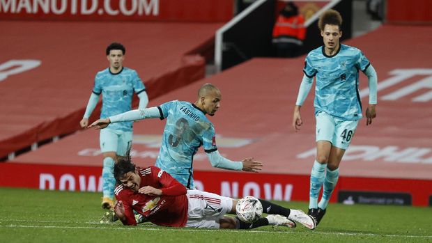 Manchester United's Edinson Cavani, falls to the ground fouled by Liverpool's Roberto Firmino during the English FA Cup 4th round soccer match between Manchester United and Liverpool at Old Trafford in Manchester, England, Sunday, Jan. 24, 2021. (Phil Noble/Pool via AP)