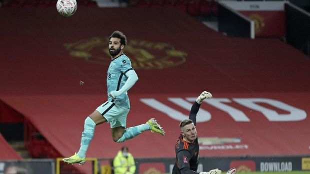 Liverpool's Mohamed Salah scores the opening goal past Manchester United's goalkeeper Dean Henderson during the English FA Cup 4th round soccer match between Manchester United and Liverpool at Old Trafford in Manchester, England, Sunday, Jan. 24, 2021. (Martin Rickett/Pool via AP)